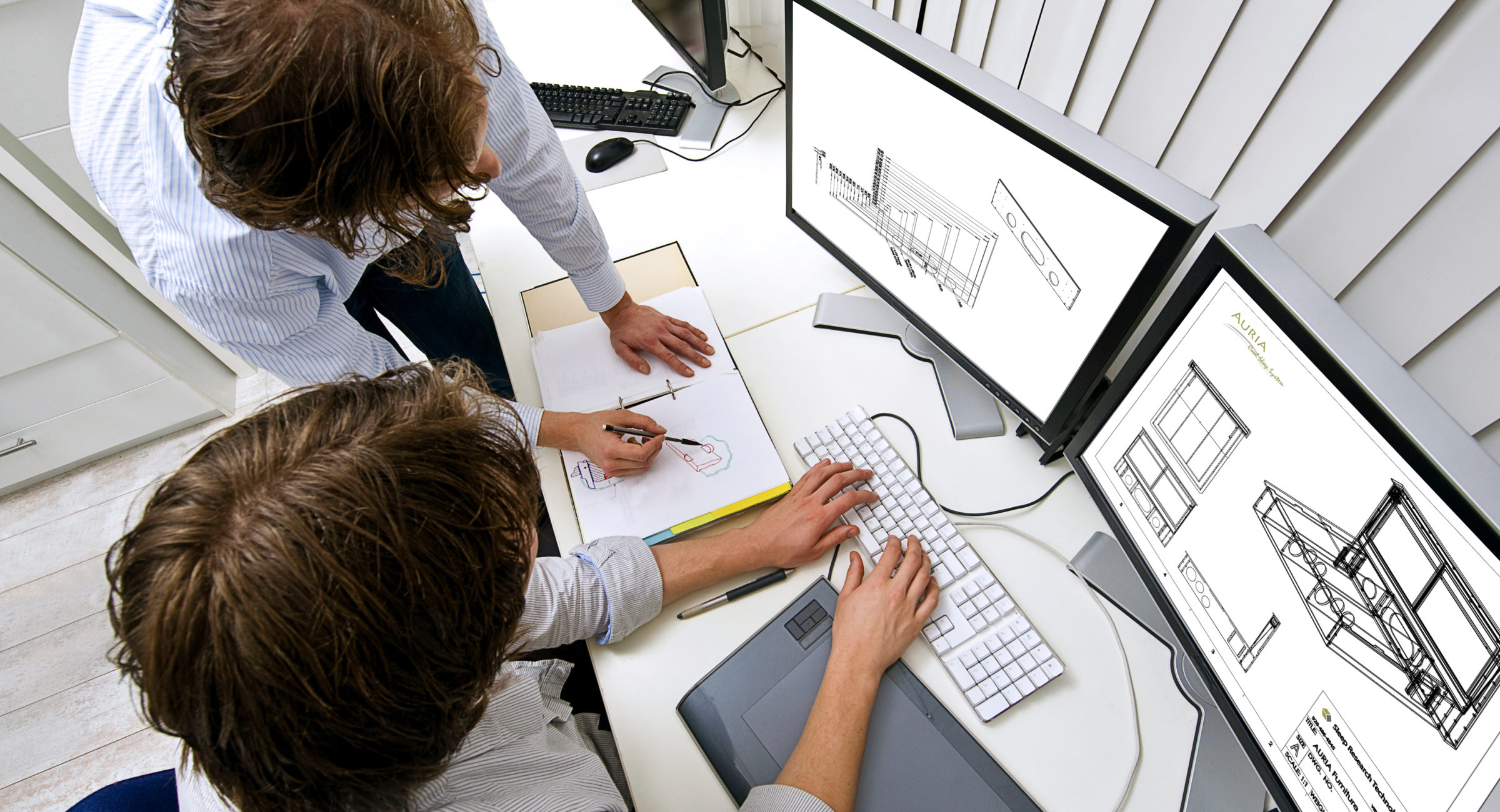 Working together Two engineers, working together in an office, one explaining something to the other